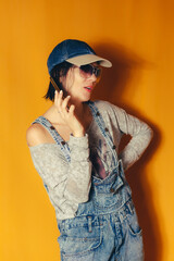 Trendy woman talking on smartphone in denim outfit