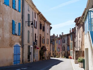 Fototapeta premium Old village of Régusse. Main Street lined with historic Provençal-style houses, known for its windmills 