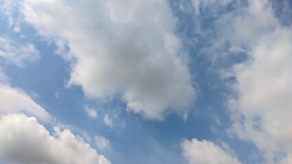 Obraz premium A dramatic cloudscape featuring towering cumulus and wispy cirrus clouds against a deep blue afternoon sky.