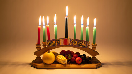 Kwanzaa kinara with lit candles and fruit on a wooden stand