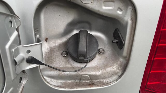 Close up detail of open fuel tank cap on silver car ready for refueling