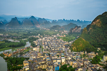 Aerial view of ancient town architecture with karst mountains landscape in Guilin, China.