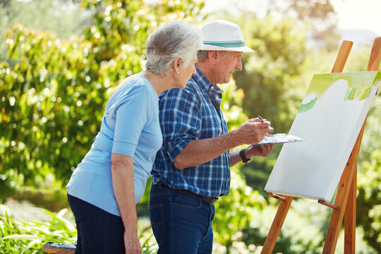 Happy, painting and elderly couple in park for bonding with artistic hobby, creativity and artwork. Retirement, marriage and senior man and woman with canvas for drawing, picture and talking outdoor - Powered by Adobe