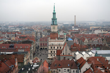 Obraz premium Central panoramic view of Poznań Town Hall and surrounding colorful historic houses under an overcast sky.