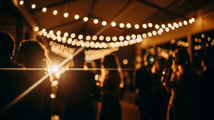 Silhouettes of people enjoying a festive evening event under warm string lights creating a magical and celebratory atmosphere