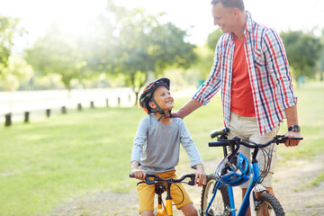 Father, son outdoor and smile with bicycle for teaching, childhood memories and bonding together....