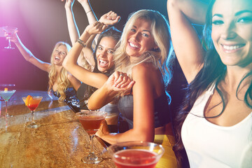 Happy, dancing and girl friends with cocktails at pub for disco, celebration or fun at event together. Portrait, smile and group of women at party with alcohol drinks at night club with energy.
