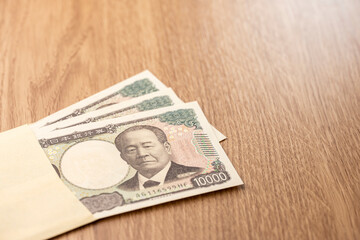封筒から広がる日本円一万円札と資金のコンセプト