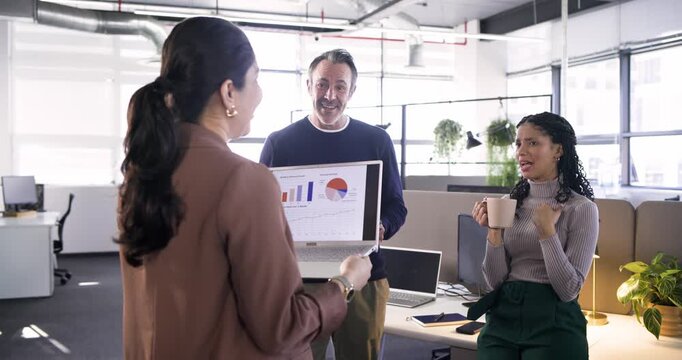 Diverse coworkers responding to laptop chart reveal, nodding and laughing during briefing at office