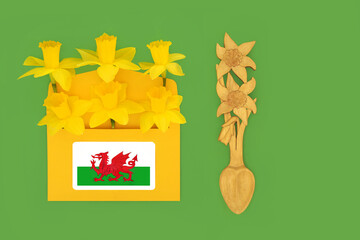 Happy St Davids Day with daffodils bouquet in envelope with daffodil flower love spoon, national red dragon Cymru flag. Traditional symbols of Wales.