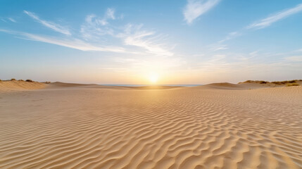 Fototapeta premium Sunset sand dune landscape warm rippled sand under expansive blue sky