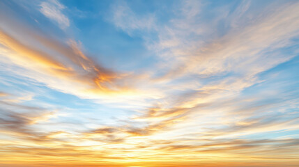 Golden blue dramatic sunrise sky with wispy clouds creating warm glow