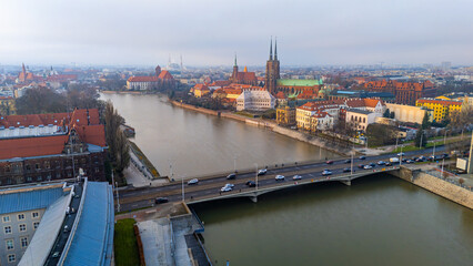 Aerial view of Wrocław’s Ostrów Tumski with the Oder, bridge, historic churches, colorful townhouses and the panoramic city skyline