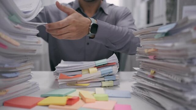 office employee searching and arranging documents with files and paperwork on Desk