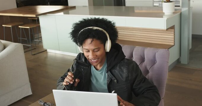 Sitting upright triggers African American man leaning forward gesturing recording podcast at desk