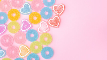 Colorful gummy candy on a pink background.