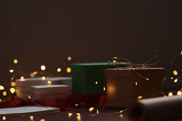 Gift boxes and festive packaging with christmas light on a table closeup