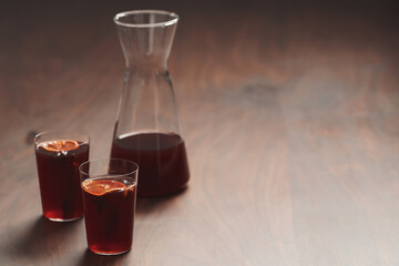 Mulled wine in tumbler glasses on walnut table with copy space