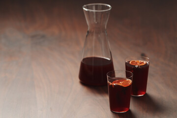Mulled wine in tumbler glasses on walnut table with copy space