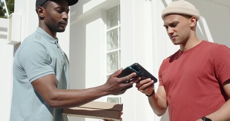Courier and customer on payment prompt holding device tapping phone porch completing pizza handoff