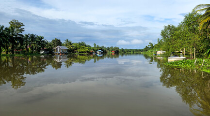Fototapeta premium Tropical River Tha Sathon with stilt houses, Surat Thani, Thailand, Southeast Asia.
