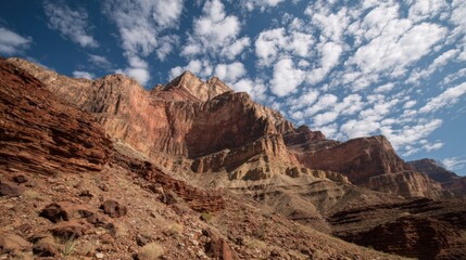 Fototapeta premium View of Layered Red Rock Cliffs Under a Blue Sky in a Desert Landscape With Clouds