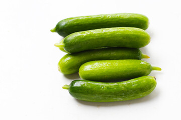 Fresh mini baby cucumbers on white background