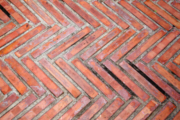 Orange brick pavement laid in a classic herringbone pattern