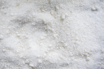 A close-up texture shot of white table salt crystals forming a granular mound, highlighting the...