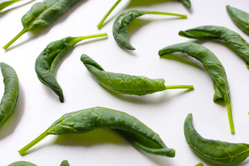 Curled spinach leaves on white background.