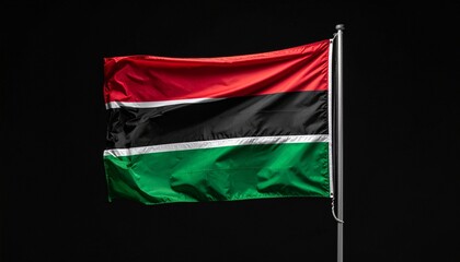 Pan-African flag waving on silver pole against black background