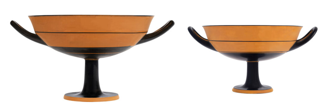 Two ancient kylix drinking cups with orange and black bands on a pedestal base isolated on white background