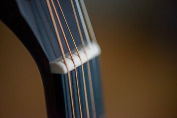 A sharp close-up photograph of an acoustic guitar highlighting its strings, wood texture, and...