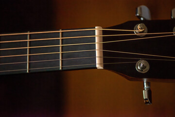 A sharp close-up photograph of an acoustic guitar highlighting its strings, wood texture, and...