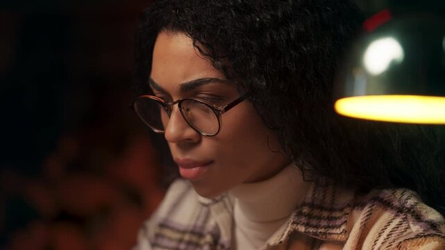 Focused African American female writer typing on laptop while working in study