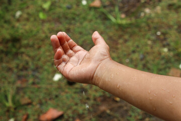 Close up of a child hand with falling raindrops