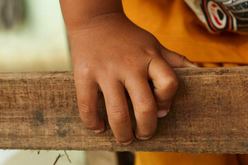 Close up of a child hand holding a piece of wood