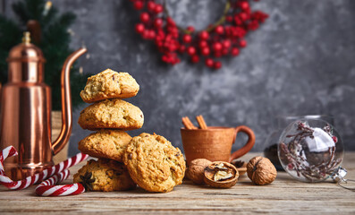 Homemade cookies with cup coffee nuts and copper coffeepot on old wooden board in rustic style. Still life with festive treats.