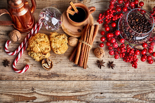 Black coffee with cookies cinnamon and spice on old wooden board in rustic style, top view. Christmas composition with baking and hot drink in cup.
