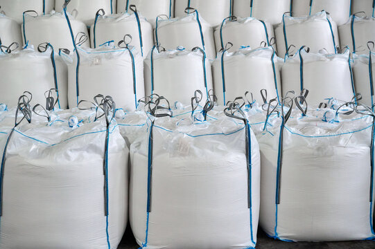 Large warehouse filled with bulk bags of products stacked for storage in a clean indoor environment