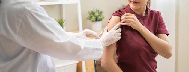 People getting a vaccination to prevent pandemic concept. Woman in medical face mask receiving a dose of immunization coronavirus vaccine from a nurse at the medical center hospital