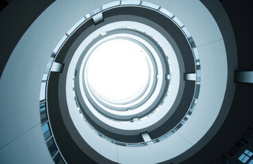 Fototapeta premium Spiral atrium with concentric balconies and round skylight overhead in blue