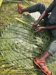Gardener preparing mats from palm trees in tropical areas. Organic and sustainable agriculture and production.