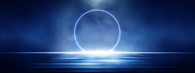 Fototapeta premium Glowing neon circle on a dark wall creates a strong blue futuristic mood. Bright reflections on the wet floor add a clean, modern, abstract look ideal for tech, sci-fi, and digital design concept