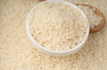 Grated coconut powder. Dry coco flakes pile, shredded desiccated coconut, tropical fruit chips