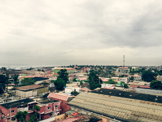 Naklejka premium Coastal Town Skyline Under Cloudy Sky — West Africa