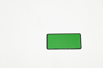 horizontal smartphone with green screen on pure white background for universal design tasks. phone with chromakey screen in horizontal orientation, ideal for inserting interfaces and video content.