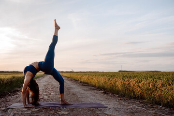 Fototapeta premium Beautiful woman doing yoga at sunset