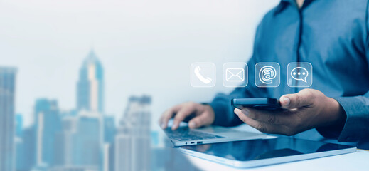 A person using a smartphone and laptop with digital contact icons represents modern business communication, customer support, online connectivity, professional networking in todays digital workplace.