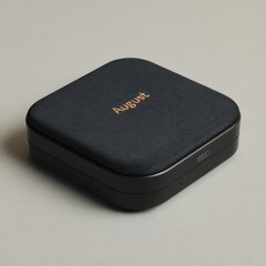 A sleek, dark square portable case with a fabric top and charging port on a light surface